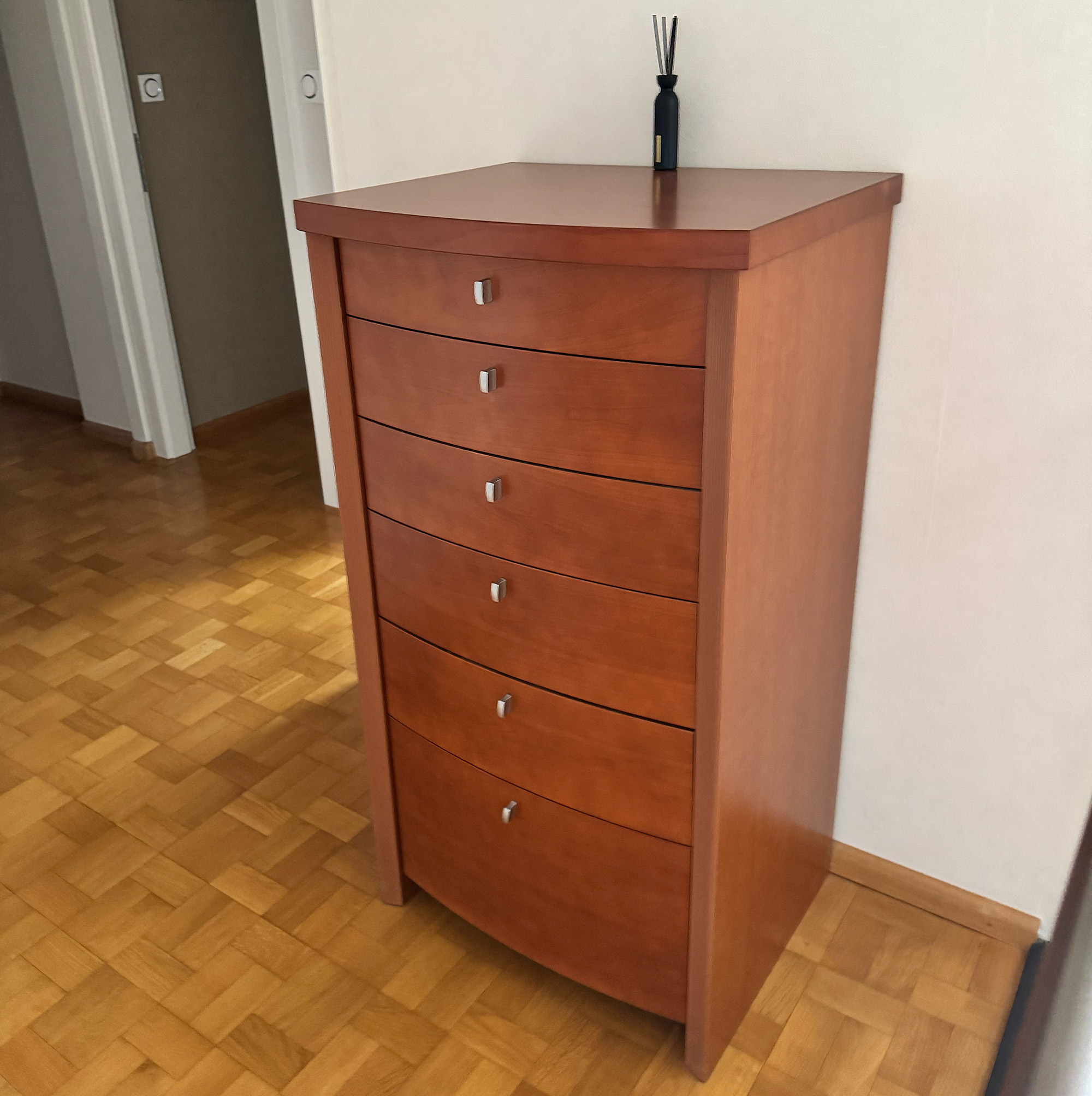 Autrefois en finition acajou foncé, ce meuble a été entièrement métamorphosé grâce au covering architectural. Il arbore désormais un élégant bois clair associé à un blanc chaleureux, pour un résultat résolument plus contemporain.
